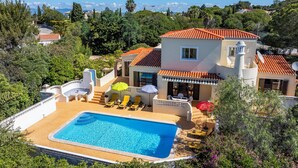 Une maison à deux étages dotée d’une piscine, d’un espace extérieur aménagé et offrant une vue sur le paysage environnant.