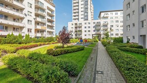Een woongebouw met meerdere balkons, een speeltuin en verzorgde tuinen.
