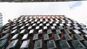 A high-rise building with a grid of windows and a brick facade. - Student Only Shoreditch (London)