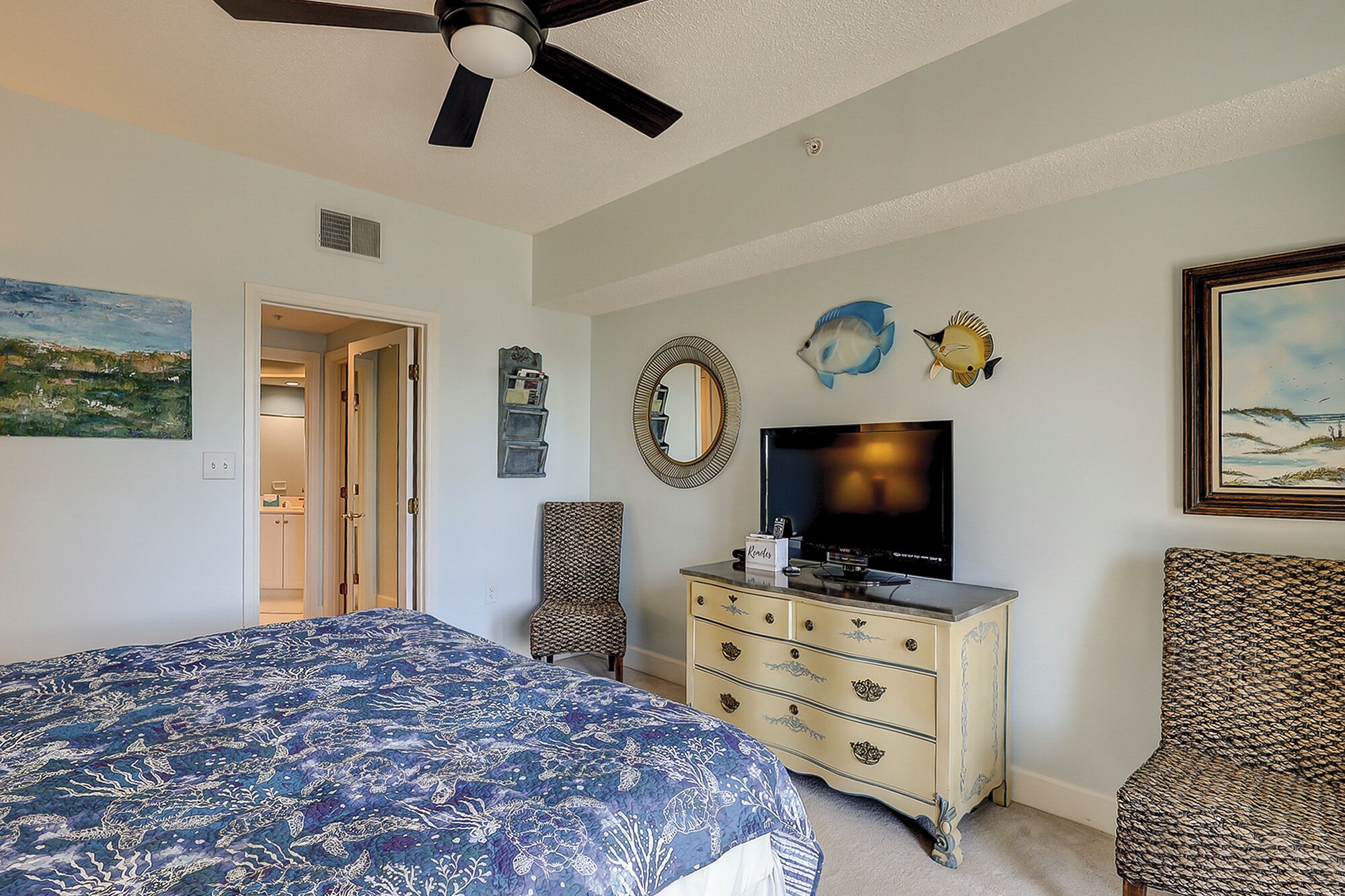 Ein Schlafzimmer mit Bett, Kommode, Fernseher und Bildern.