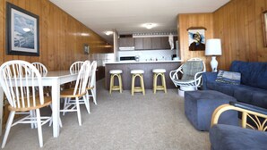 Un espace de vie compact comprenant un coin repas, une cuisine et un coin salon.
