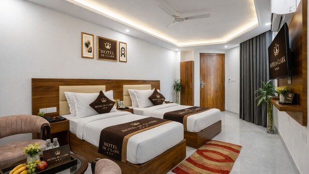 Habitación de hotel con dos camas, un escritorio, una silla, un televisor y un minibar.
