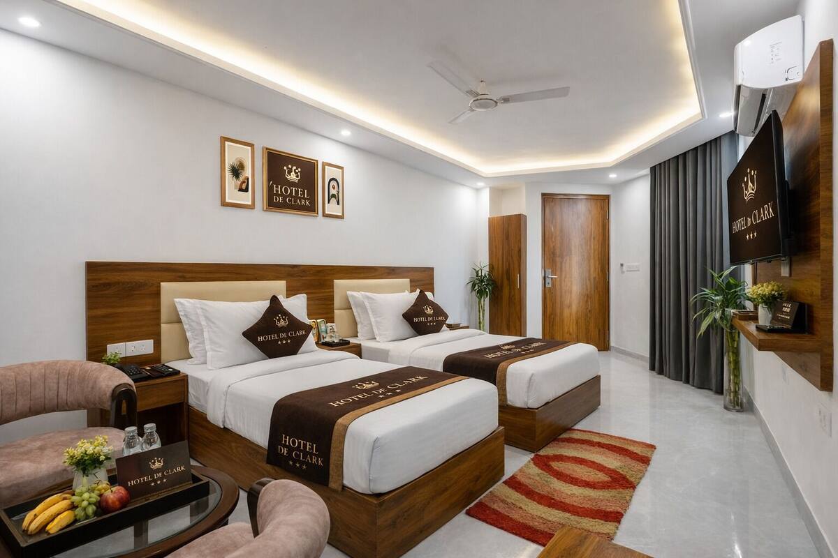 Habitación de hotel con dos camas, un escritorio, una silla, un televisor y un minibar.