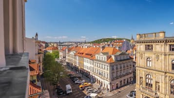 A cityscape with historic buildings, a cobblestone street, and a clear blue sky.