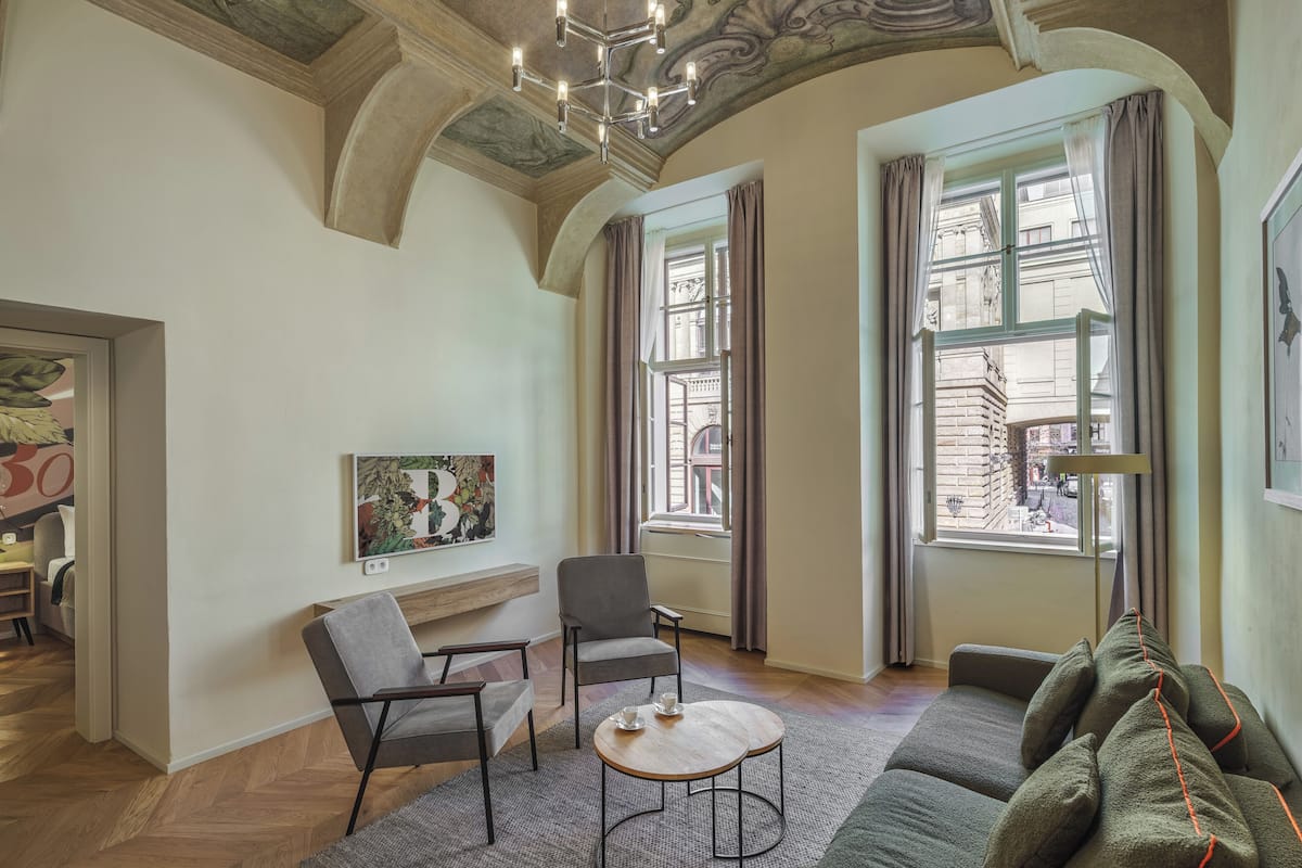 A spacious living area with a fireplace, two armchairs, a sofa, and a coffee table.