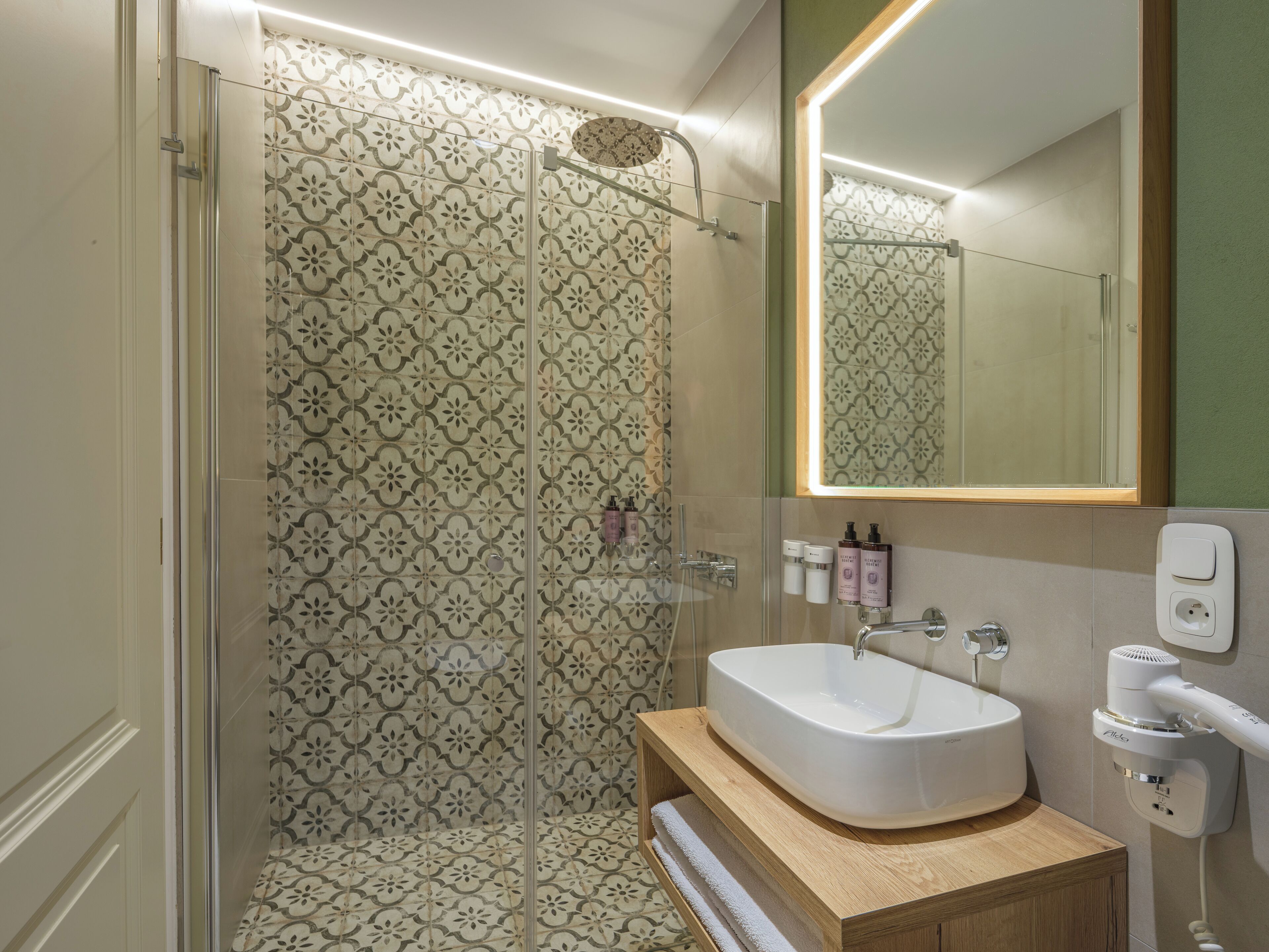 A bathroom with a shower, a sink, and a mirror.