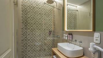 A bathroom with a shower, a sink, and a mirror.