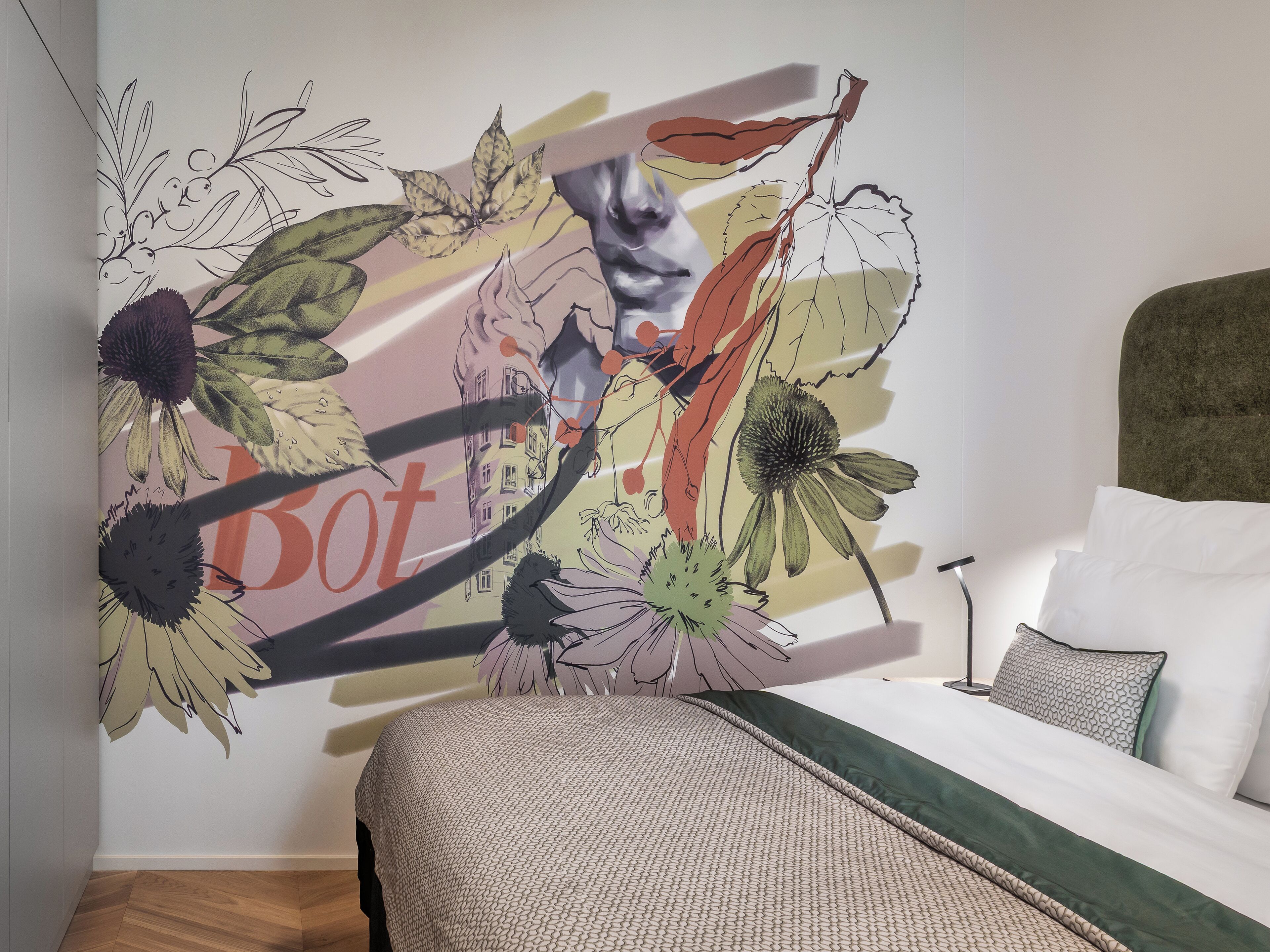 A bedroom with a bed, pillows, and a wall with a floral and abstract design.