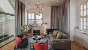 A modern living room with a sofa, chairs, a coffee table, and a TV.