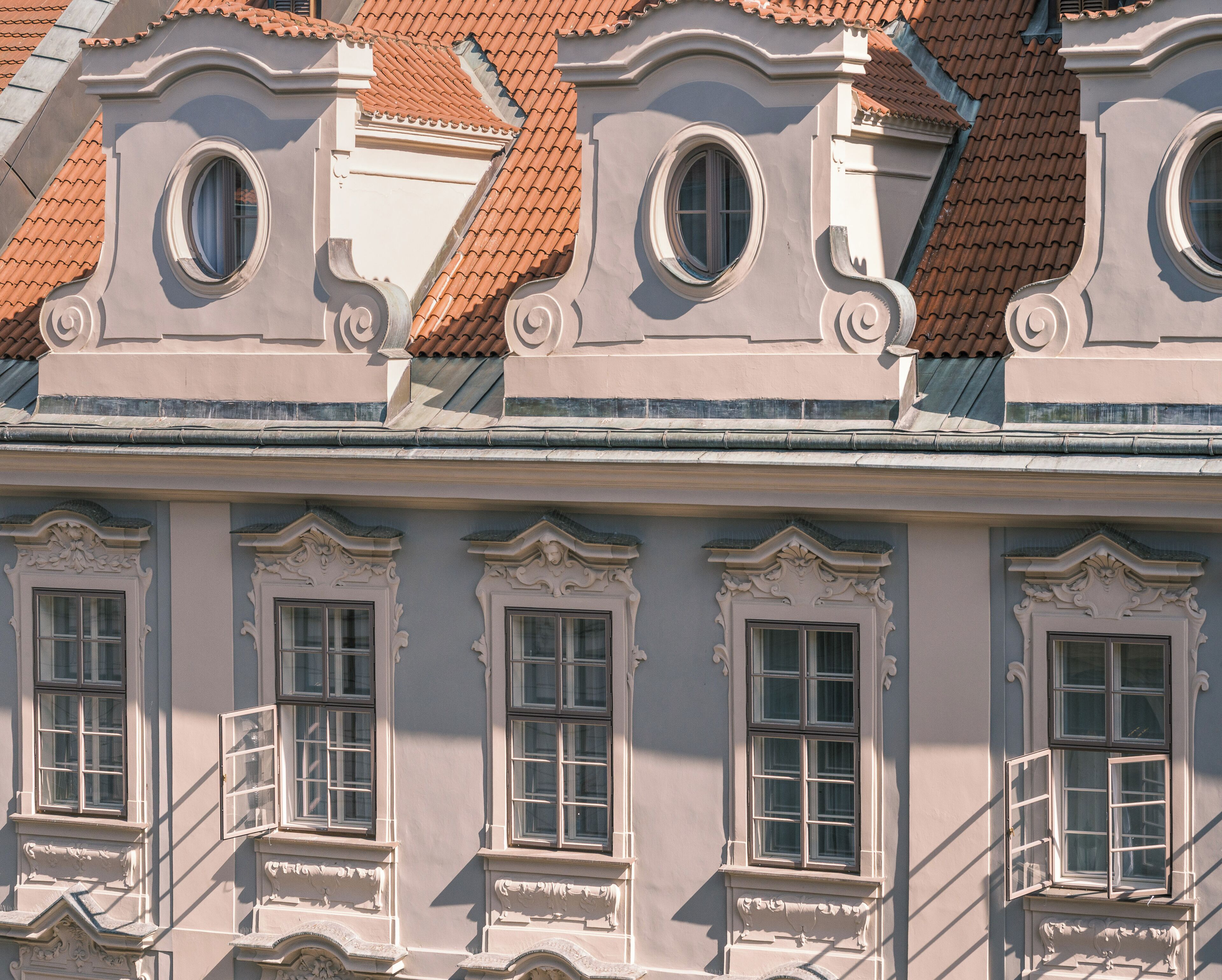 Ein Gebäude mit aufwändiger Architektur, darunter dekorative Fensterrahmen und ein Ziegeldach.