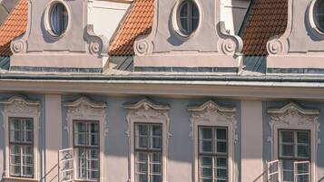 Ein Gebäude mit aufwändiger Architektur, darunter dekorative Fensterrahmen und ein Ziegeldach.