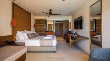 Habitación de hotel con cama, escritorio, silla y un espejo grande.