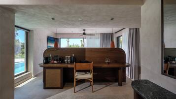 A modern kitchen with a wooden island, a dining area, and a large window with a view of palm trees.