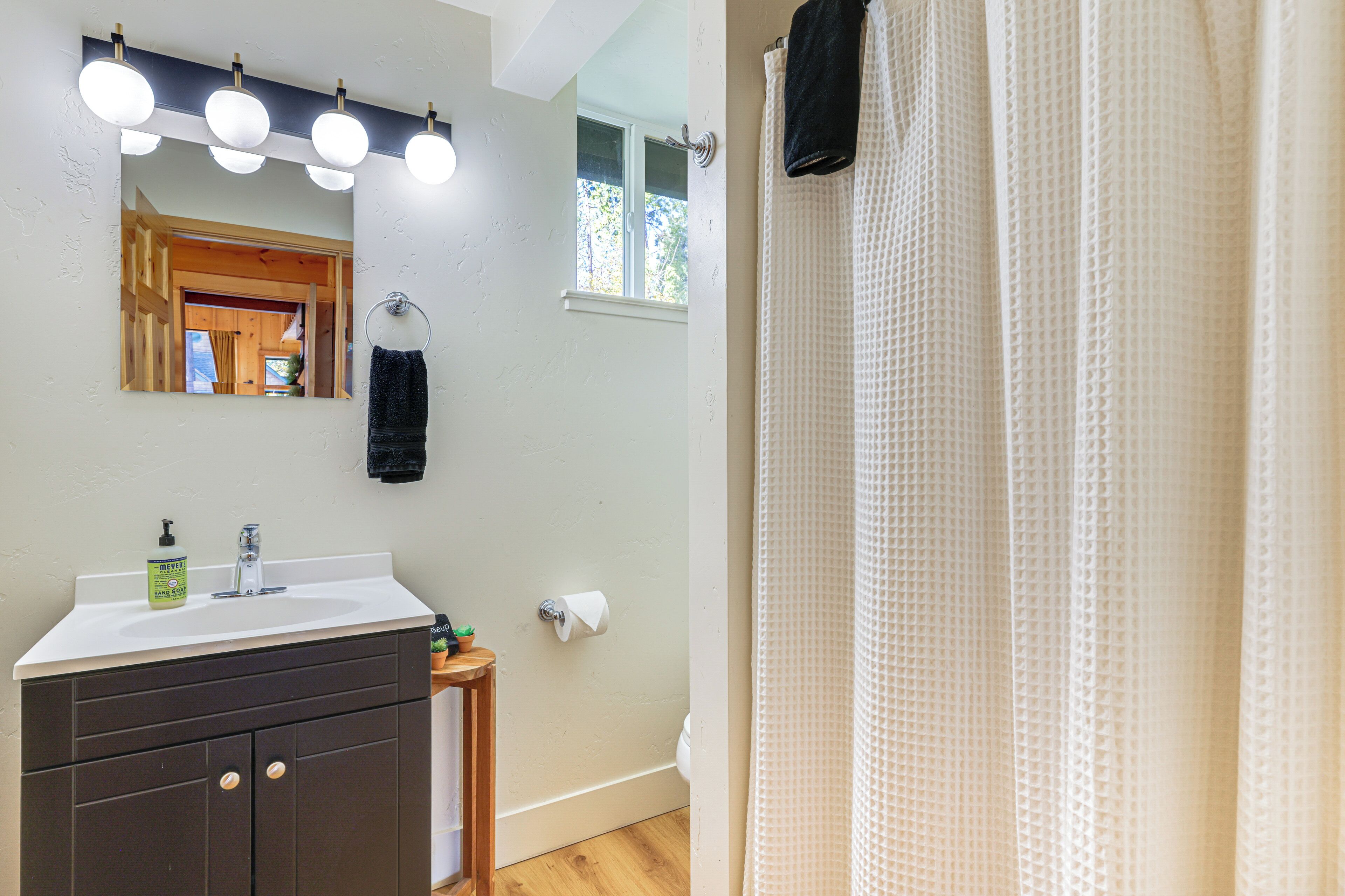 A bathroom with a sink, mirror, and towel rack.