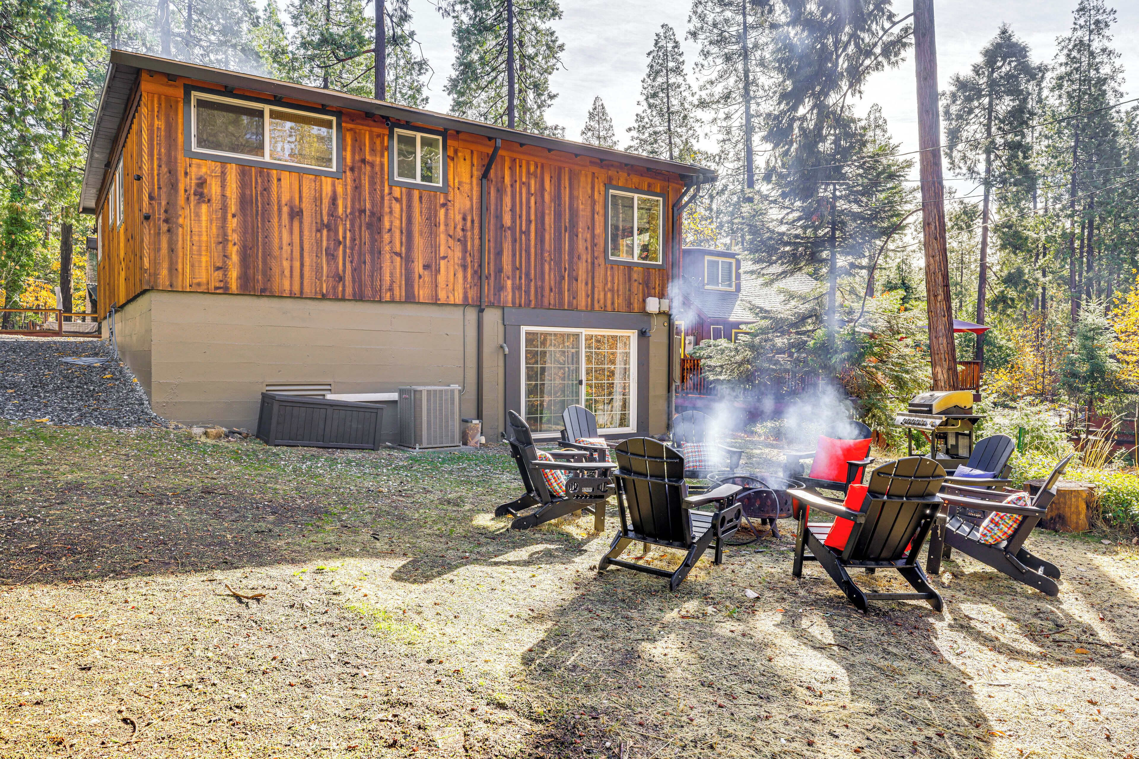 A wooden cabin with a fire pit and outdoor seating.