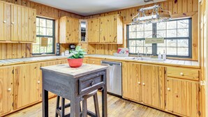 Une cuisine avec des meubles de rangement en bois, un évier et un lave-vaisselle.