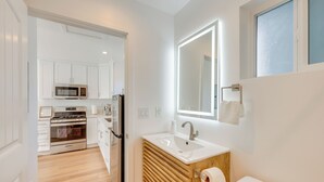 A modern kitchen with white cabinets, a stainless steel oven, and a microwave. - 35 Mi to LA: Modern Apartment in Chino! (Chino)