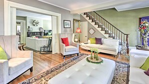 A spacious living room with a staircase, a dining area, and a kitchen visible through an open doorway. - Walk to Keuka Lake! Fun, Spacious Retreat w/ Pool (Hammondsport)