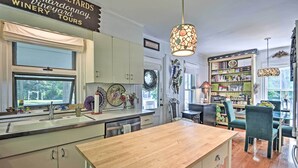 A kitchen with a wooden countertop, a sink, and a dining area with a table and chairs. There is a chandelier hanging above the dining table. - Walk to Keuka Lake! Fun, Spacious Retreat w/ Pool (Hammondsport)