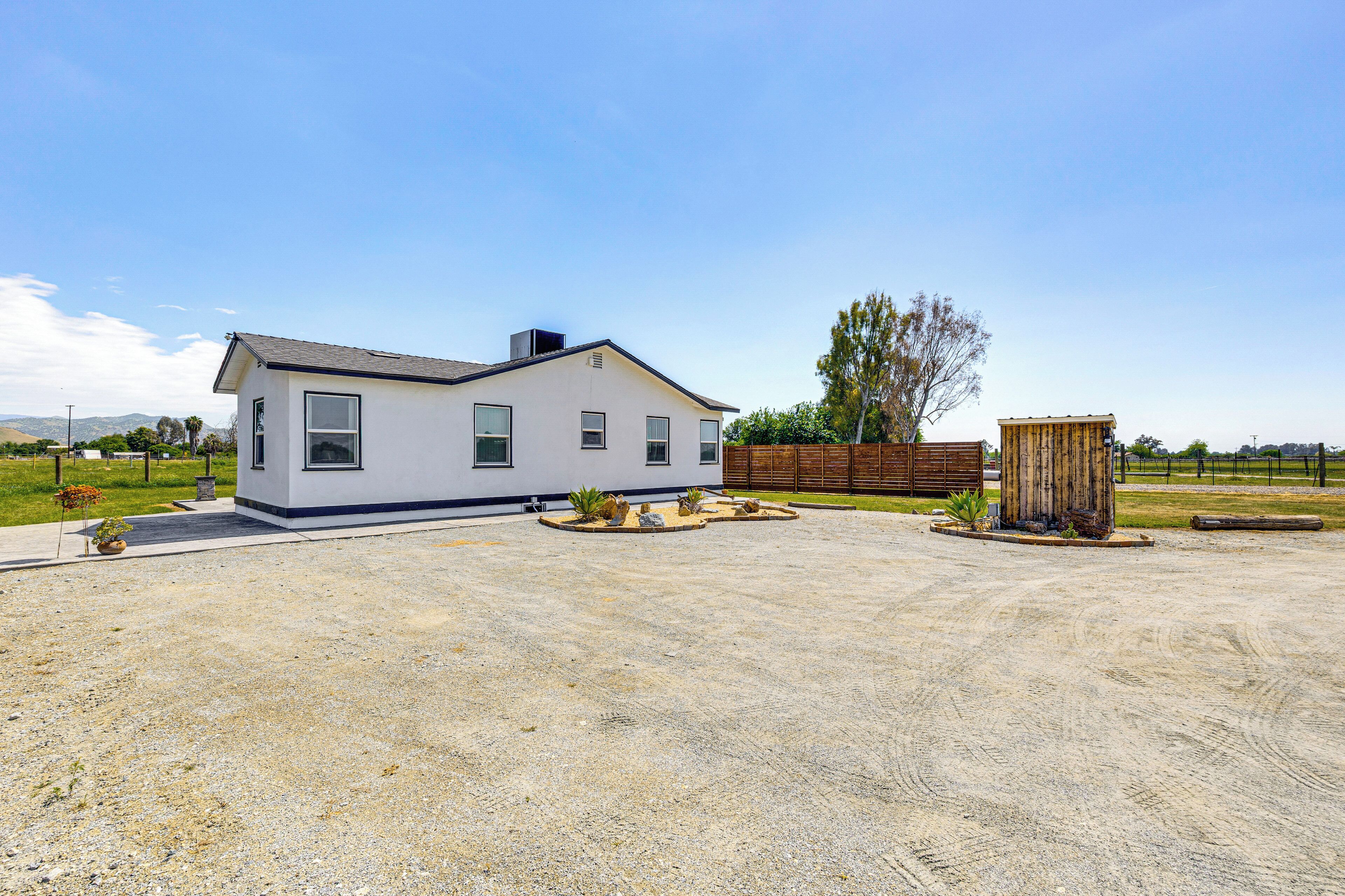 Une maison moderne de plain-pied, dotée d’une grande allée et d’une clôture en bois.