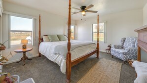 A four-poster bed with a ceiling fan, a chair with a patterned upholstery, and a view of the outdoors through a window. - 19 Mi to Sequoia Natl Park: Mtn-view Woodlake Gem (Woodlake)
