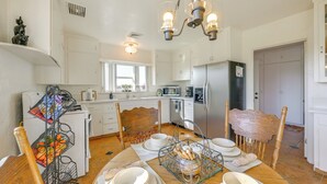 A modern kitchen with white cabinets, a dining table set with plates and bowls, and a chandelier. - 19 Mi to Sequoia Natl Park: Mtn-view Woodlake Gem (Woodlake)