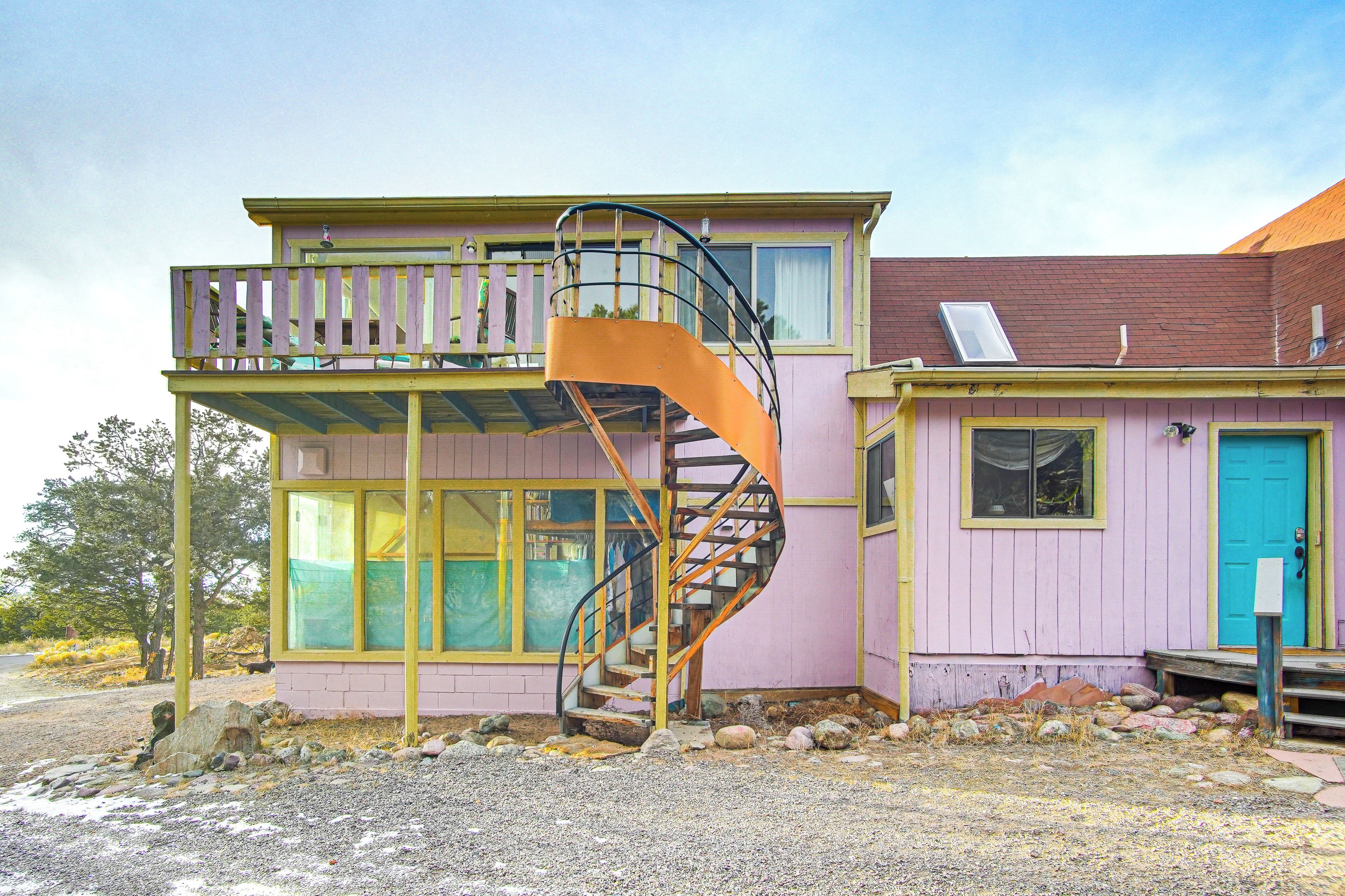 A two-story building with a spiral staircase leading to a balcony.