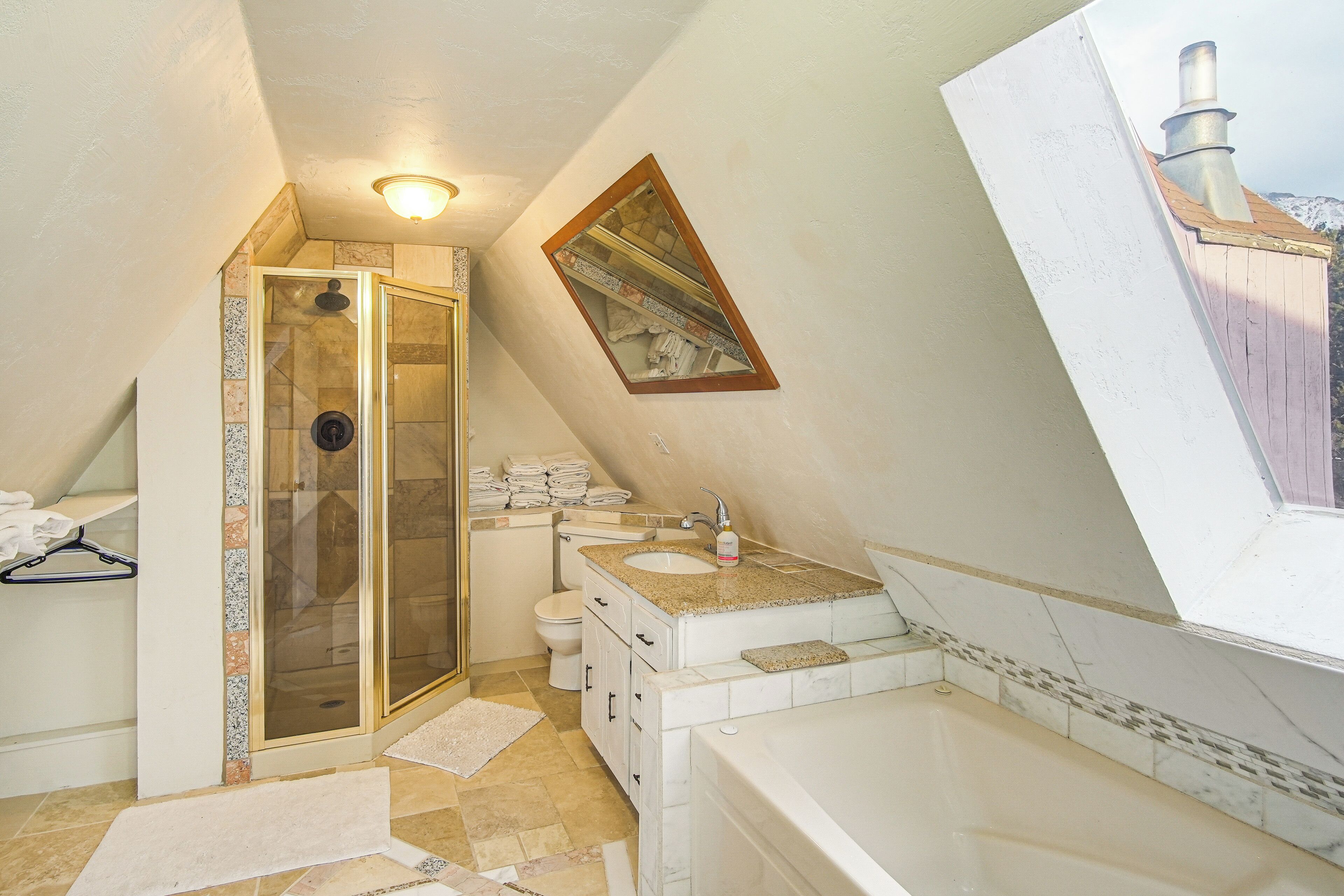 A bathroom with a glass shower enclosure, a sink, a toilet, and a bathtub.