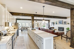 A spacious kitchen with white cabinets, a large island, and pendant lighting. - Fish, Boat & Unwind: Old Hickory Lake Retreat (Mount Juliet)