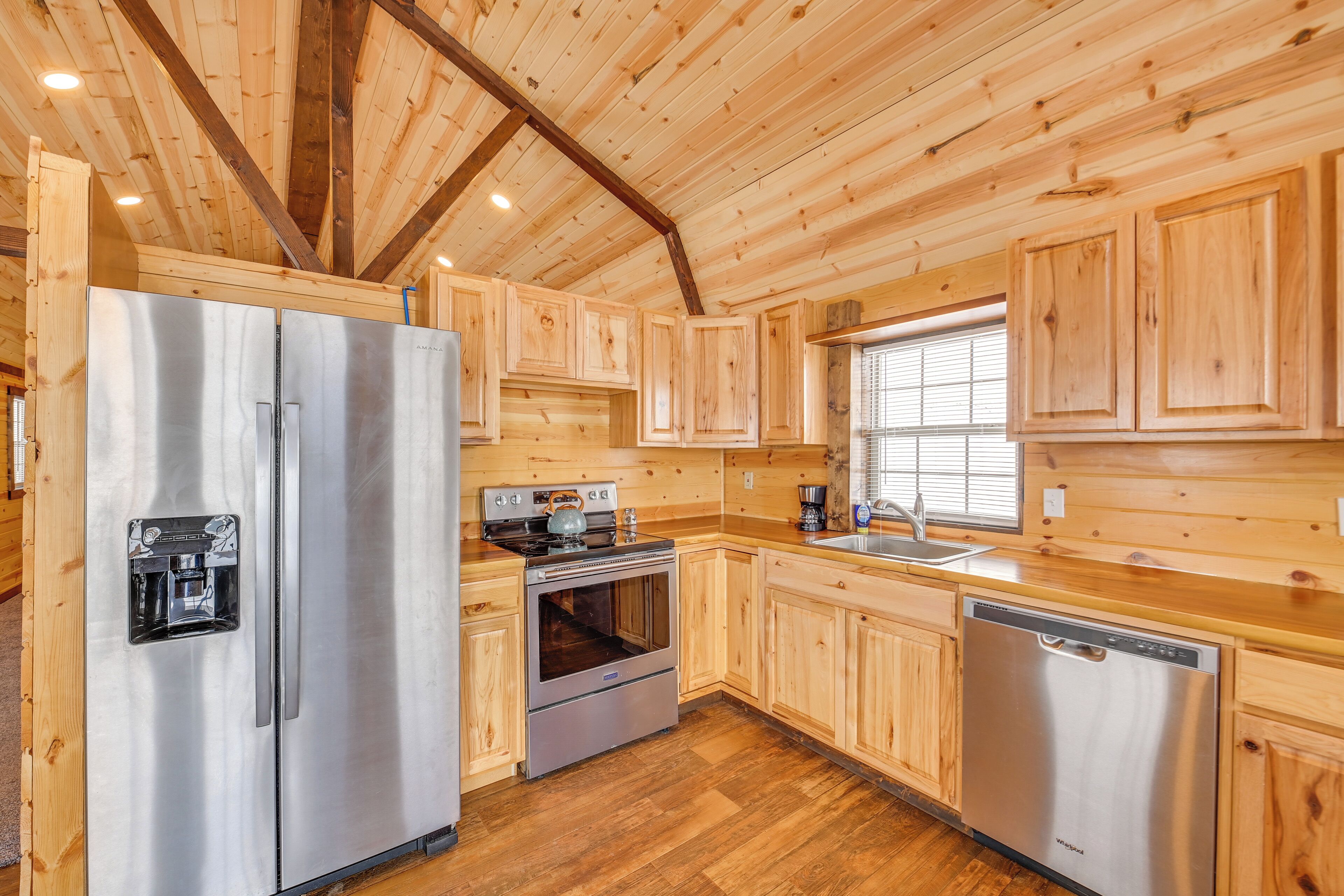 Una cocina moderna con armarios de madera, electrodomésticos de acero inoxidable y suelo de madera.