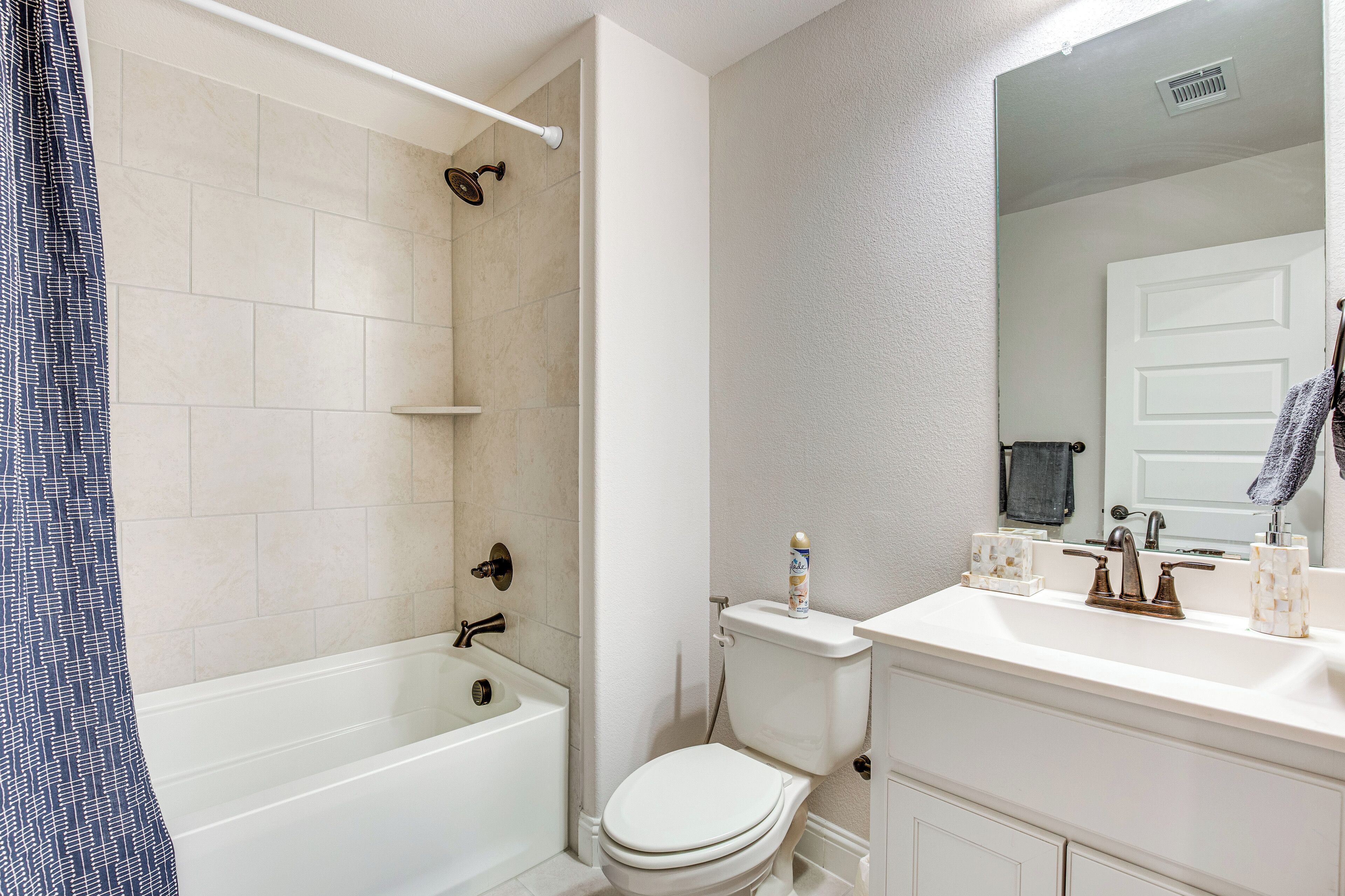 A bathroom with a bathtub, toilet, and sink.
