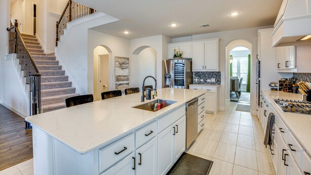 A modern kitchen with white cabinetry, a central island, and a built-in stove. - 6 Mi to Lake Lewisville: Chic Retreat in Frisco! (Frisco)