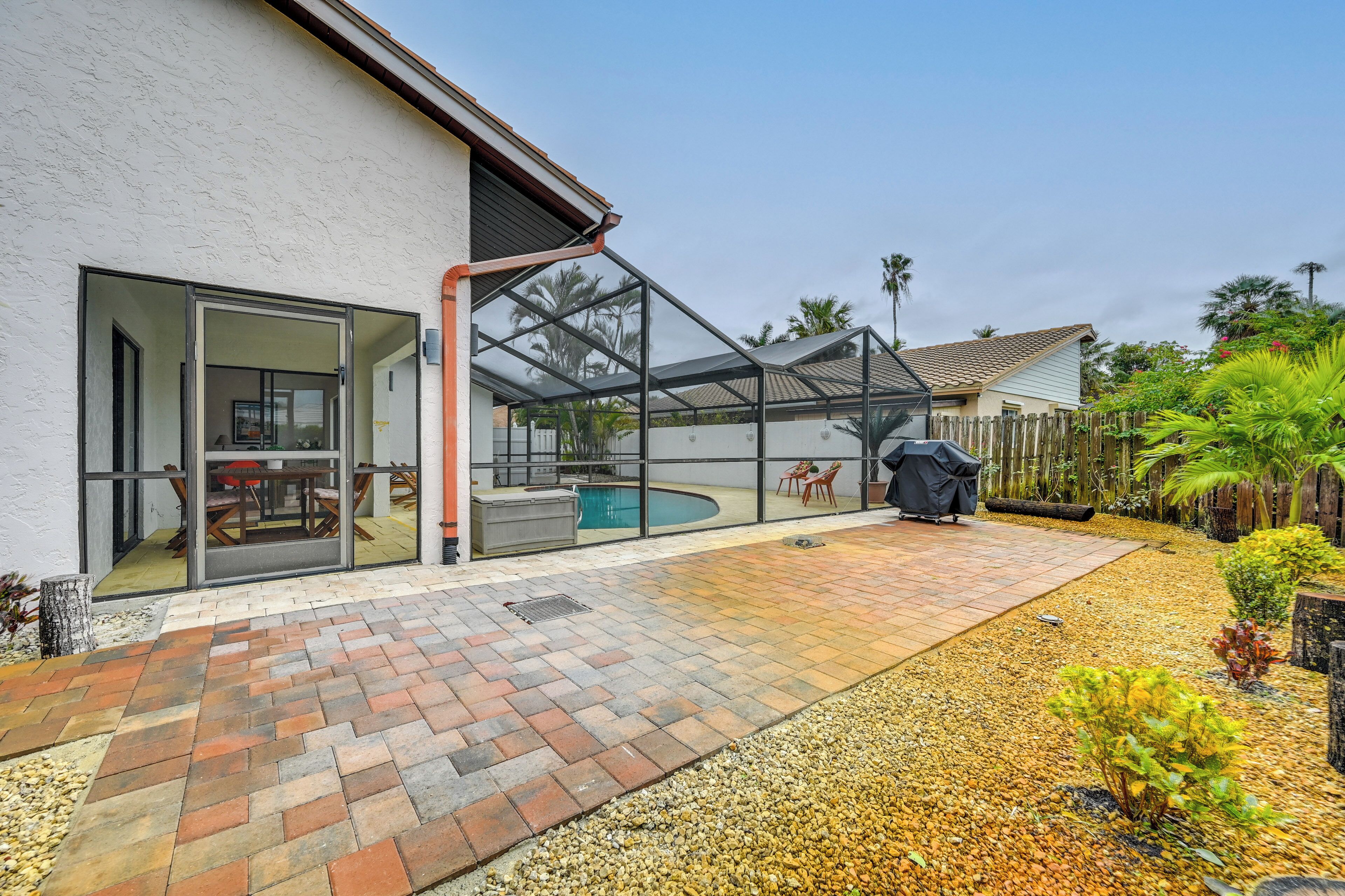 Un jardin avec une piscine, une terrasse et un espace extérieur abrité.
