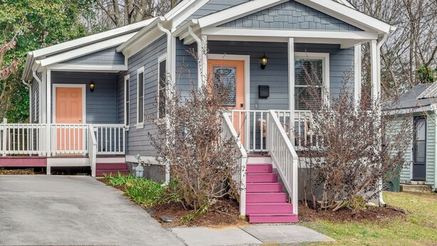 A two-story house with a front porch, a pink staircase, and a small front yard. - 1 Mi to Dtwn: Home w/ Backyard in Raleigh! (Raleigh)