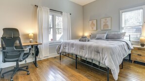 A bedroom with a bed, desk, chair, and a window with curtains. - 1 Mi to Dtwn: Home w/ Backyard in Raleigh! (Raleigh)