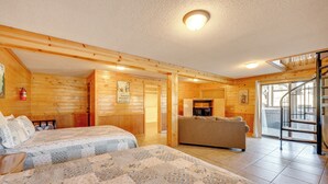 A log cabin-style room with two beds, a sofa, and a fireplace.