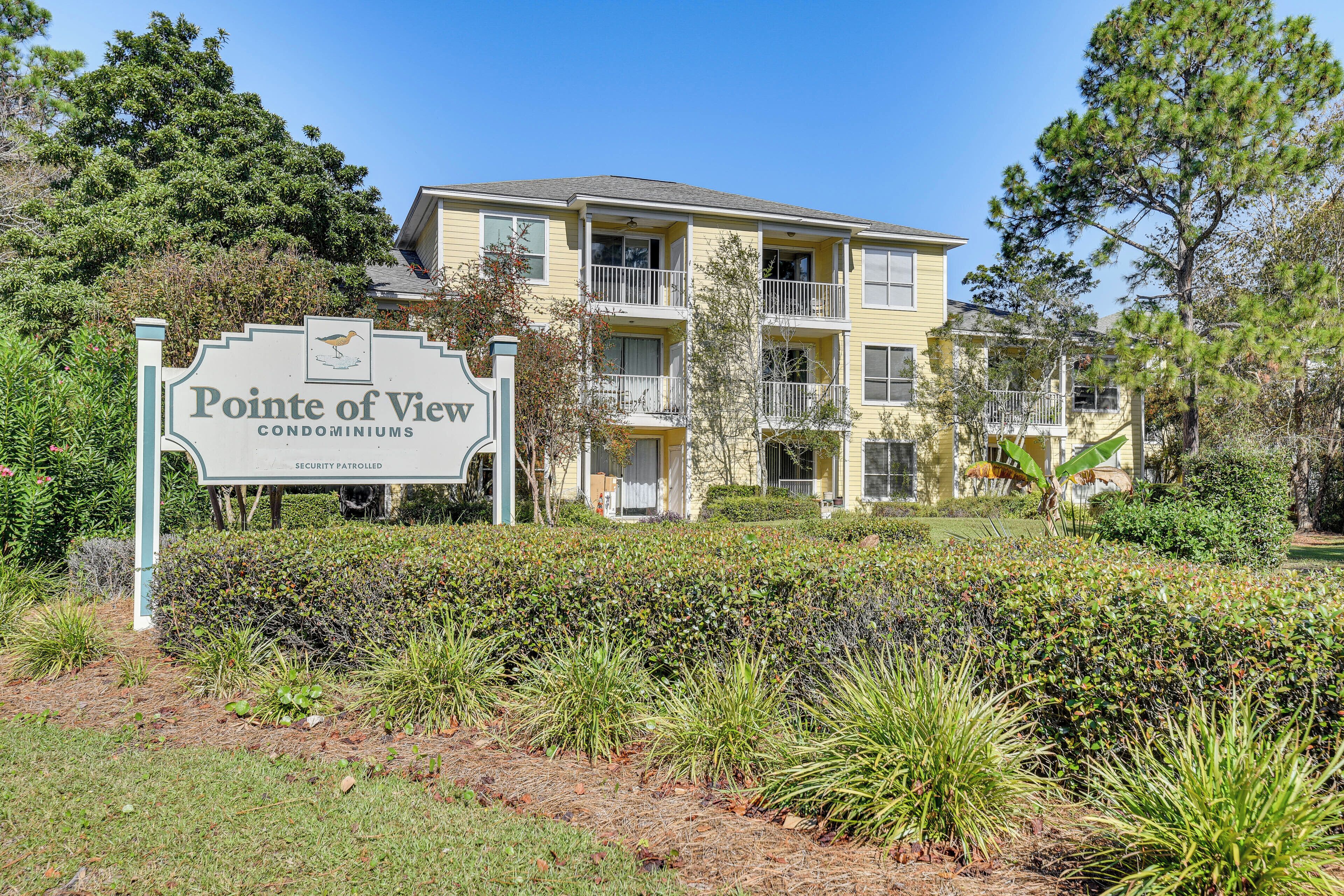 A sign for Pointe of View Condominiums with a security patrolled notice.