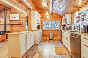 A log cabin-style kitchen with wooden walls, a large window, and modern appliances. - 5 Mi to Breckenridge Ski Resort: Cozy Wood Cabin! (Breckenridge)