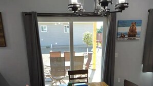 A dining area with a wooden table and chairs, a blue table runner, and a painting on the wall. - Charming 3-bedroom house with WiFi, AC minutes from Lake Oahe/ 3 stall garage (Pierre)