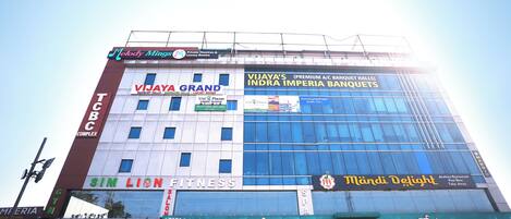 A multi-story building with various businesses including a bank, fitness center, and a restaurant.