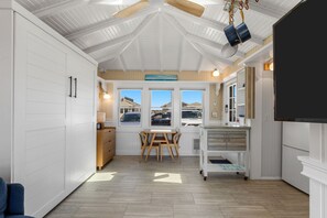 Cocina con comedor, armarios de madera y vistas al exterior.