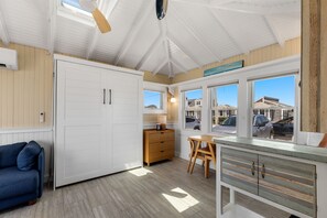 Een ruime kamer met een grote kledingkast, een houten bureau en uitzicht op het exterieur.