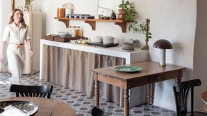 Une cuisine chaleureuse avec un plafond en arc de cercle, des étagères en bois et des luminaires suspendus.