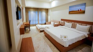 A hotel room with a large bed, a desk, a chair, and a television. - VS Imperial (Akola)