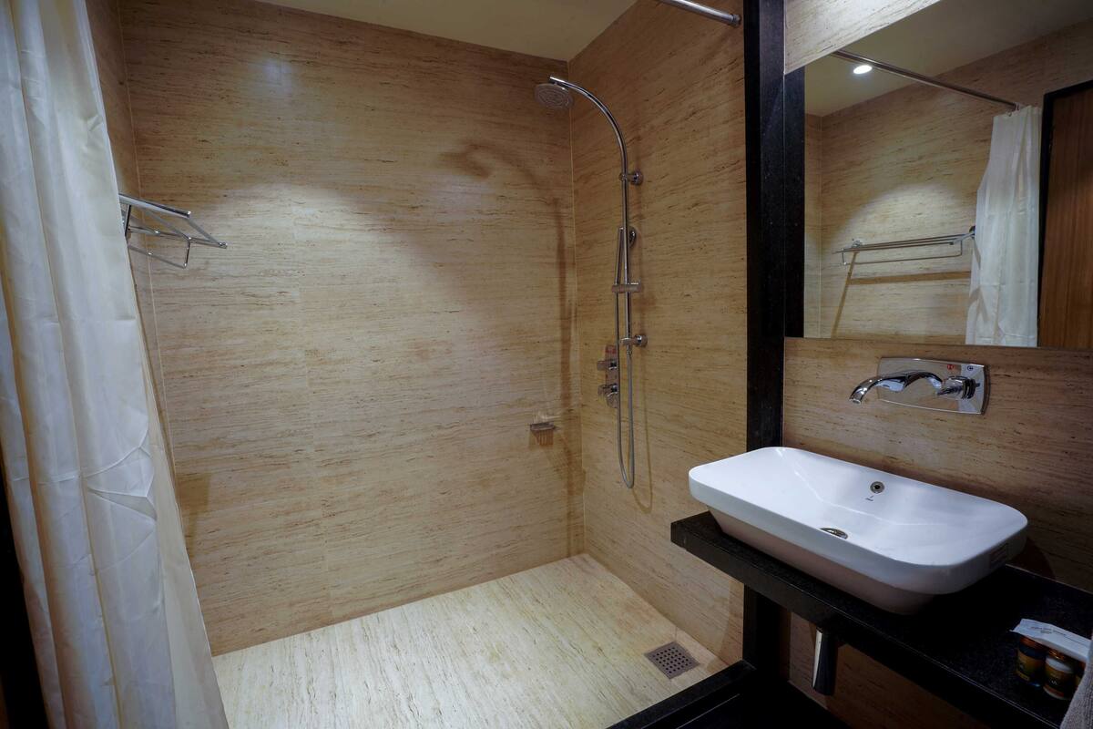 Un baño moderno con pared de madera, un lavabo blanco y una ducha.