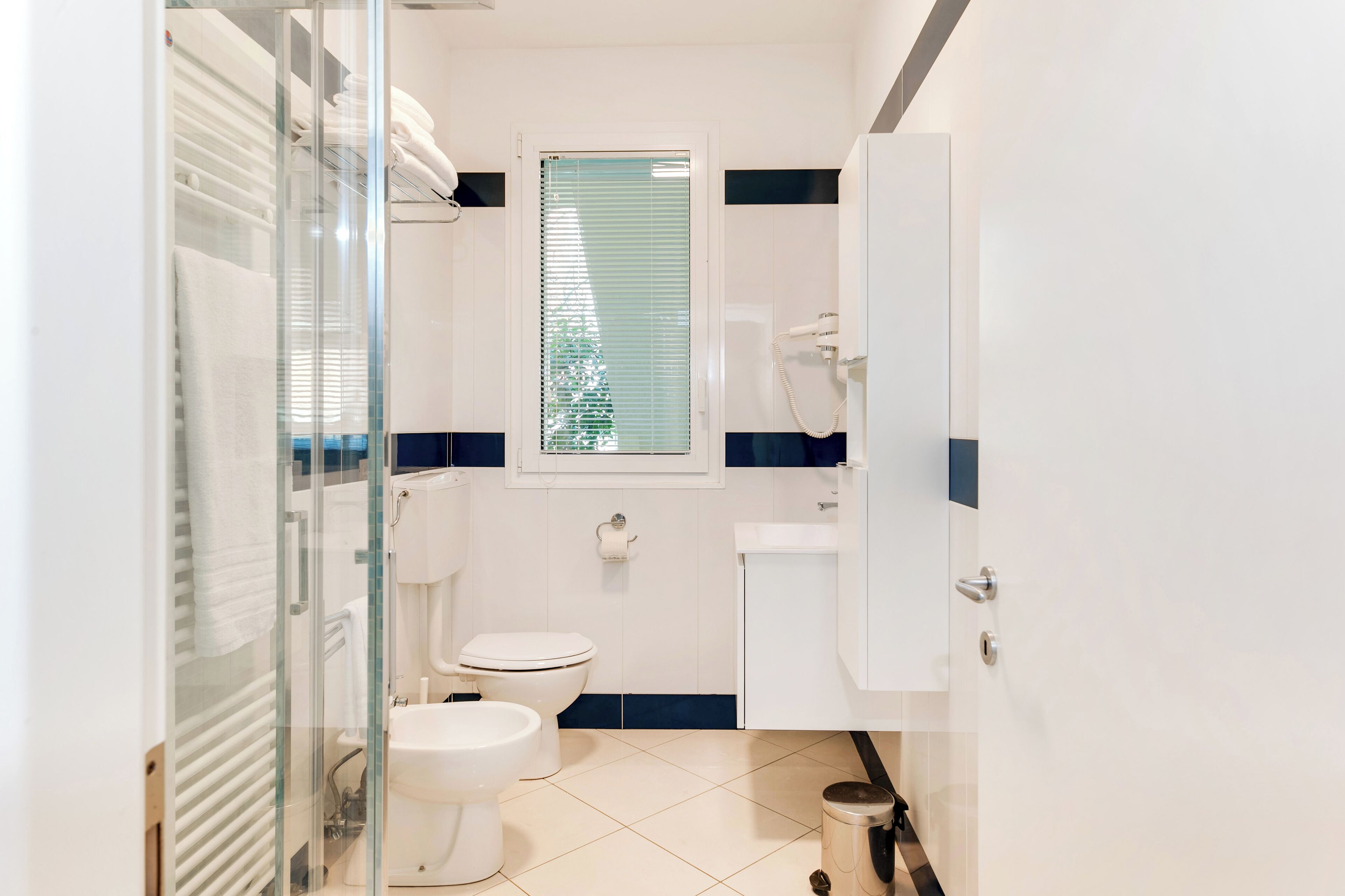 Un baño pequeño con inodoro, bidé y cabina de ducha de vidrio.