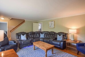 A living room with a sectional sofa, a wooden coffee table, and a patterned rug.