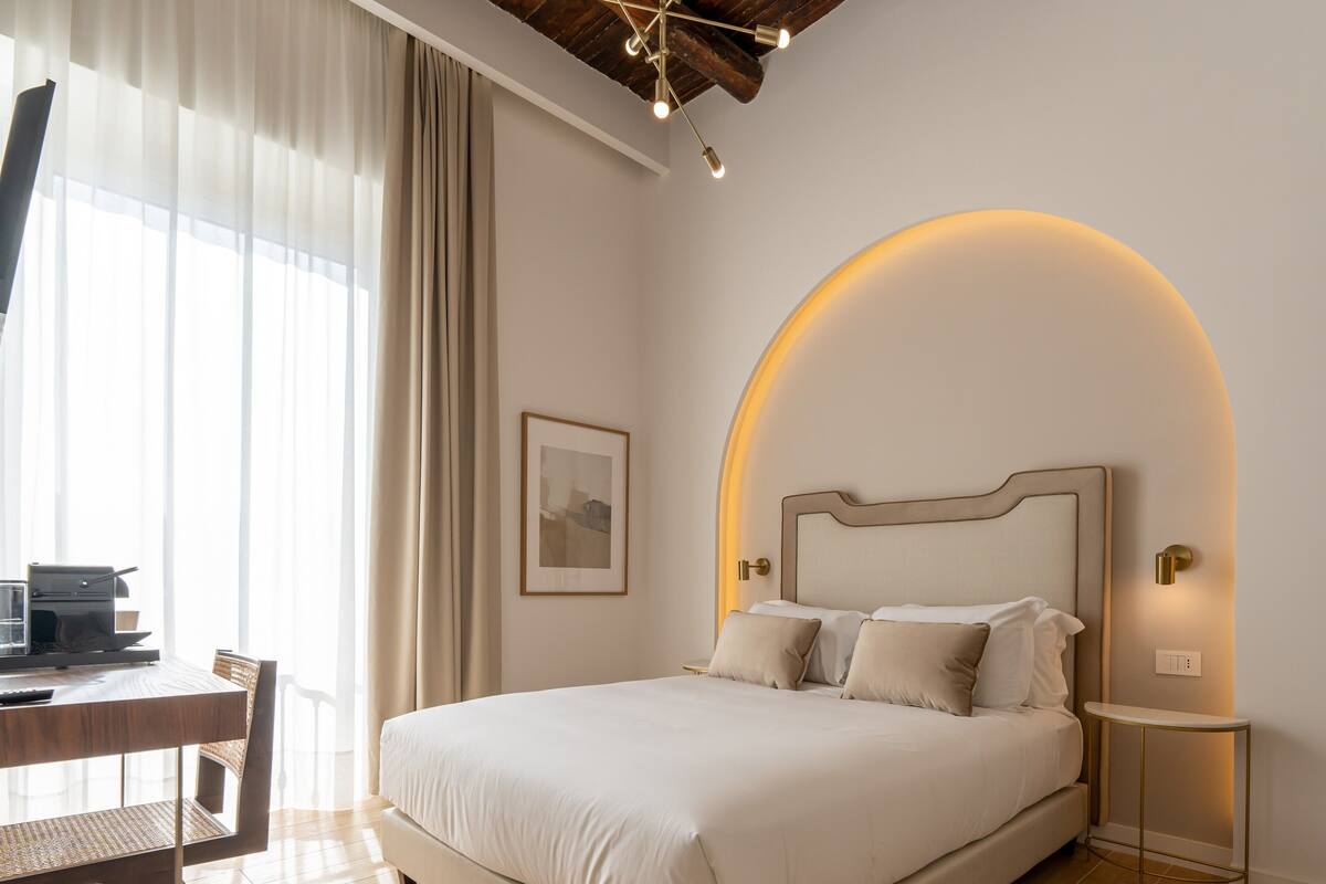 A bedroom with a bed, a desk, and a chair.