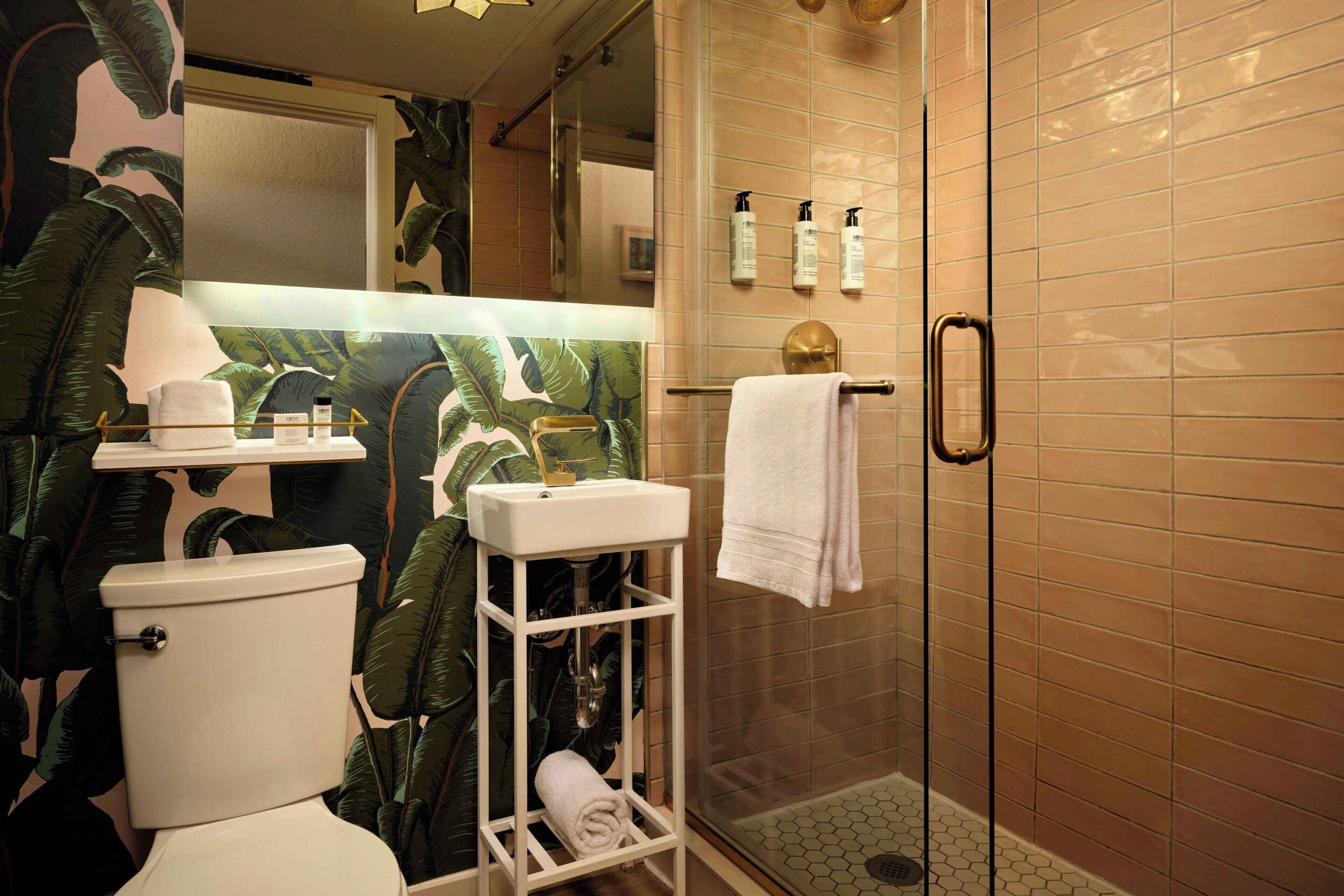 A bathroom with a toilet, sink, and shower area.