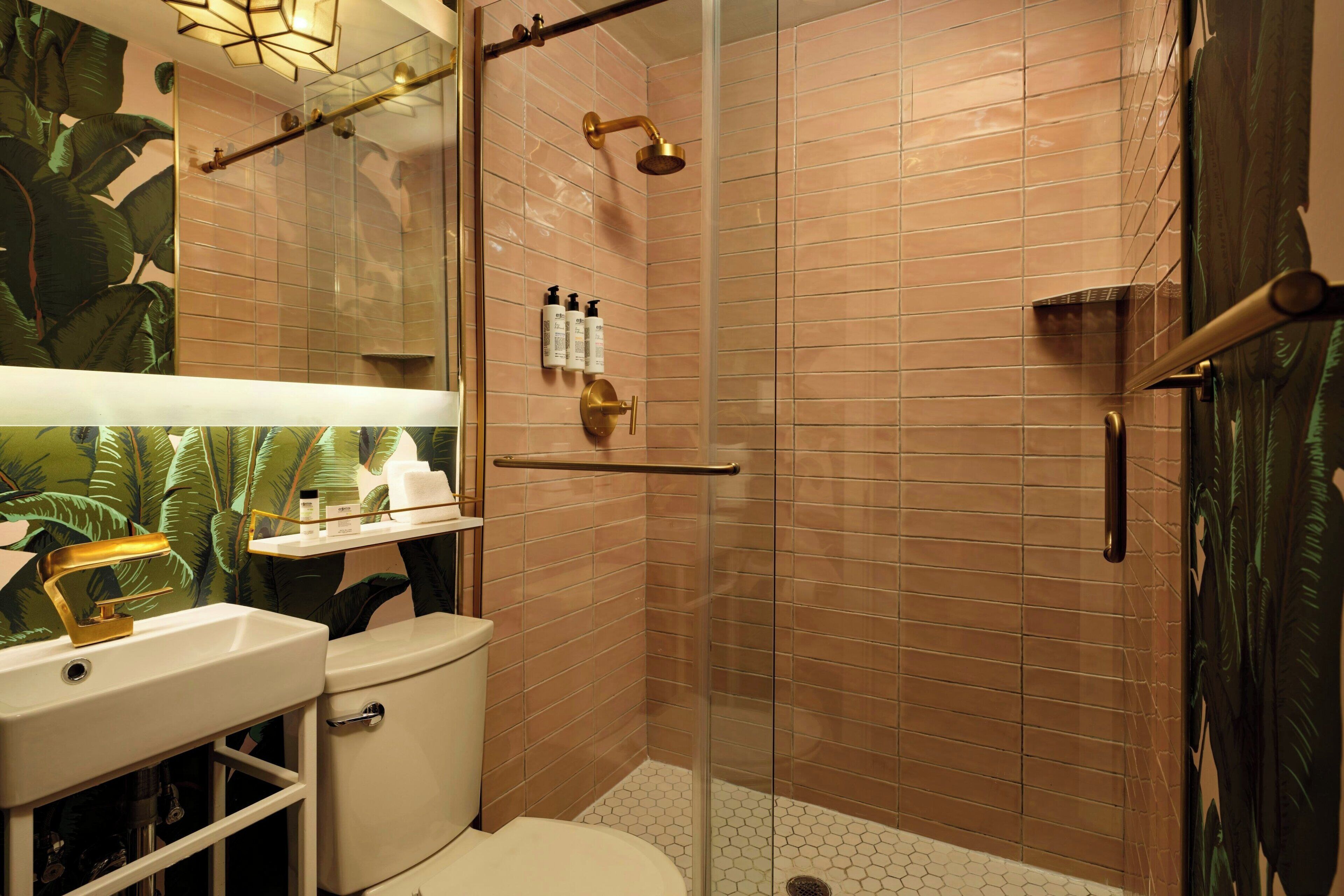 A modern bathroom with a glass-enclosed shower, a white sink, and a toilet.